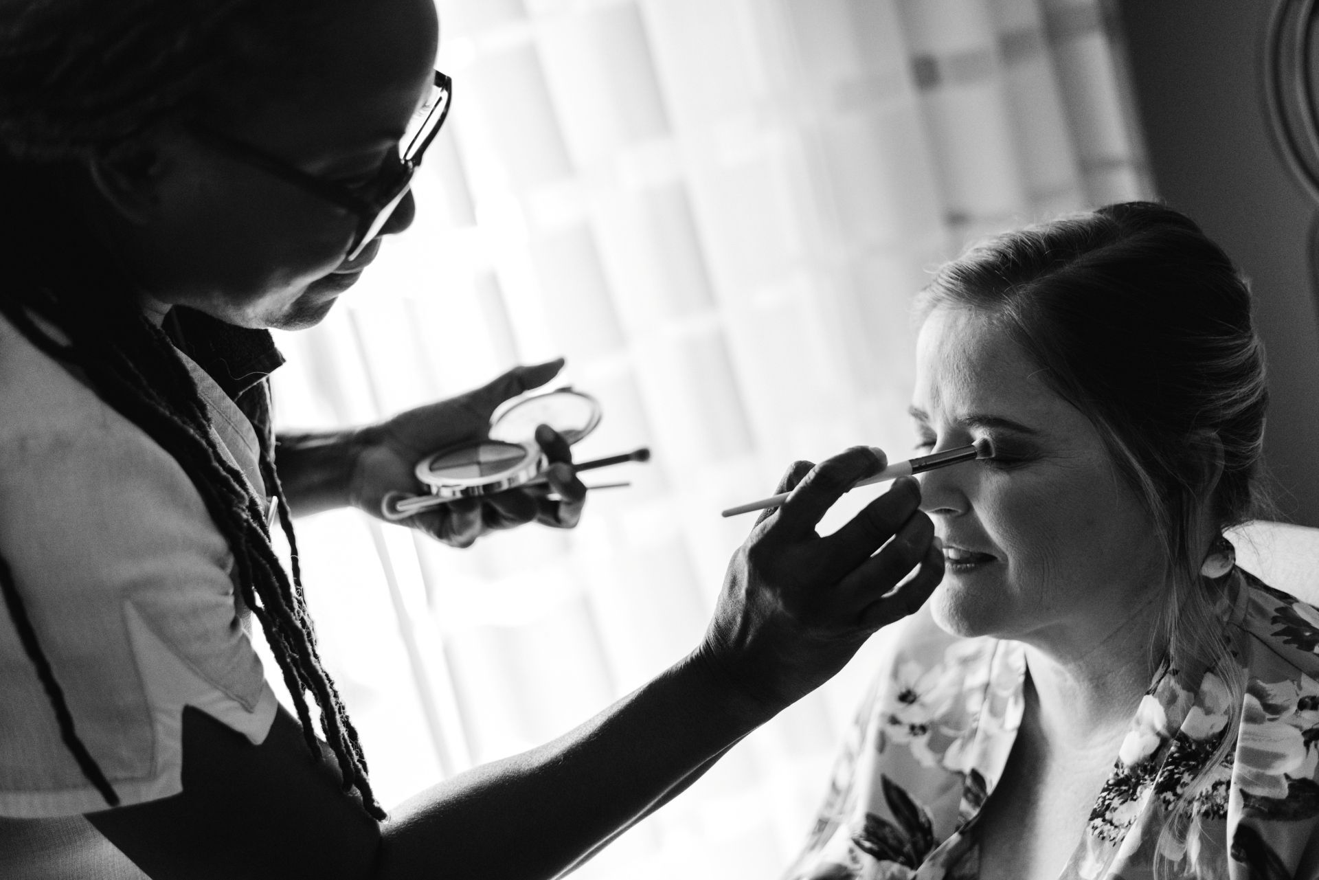 expert-staff-supporting-bride-with-applying-makeup