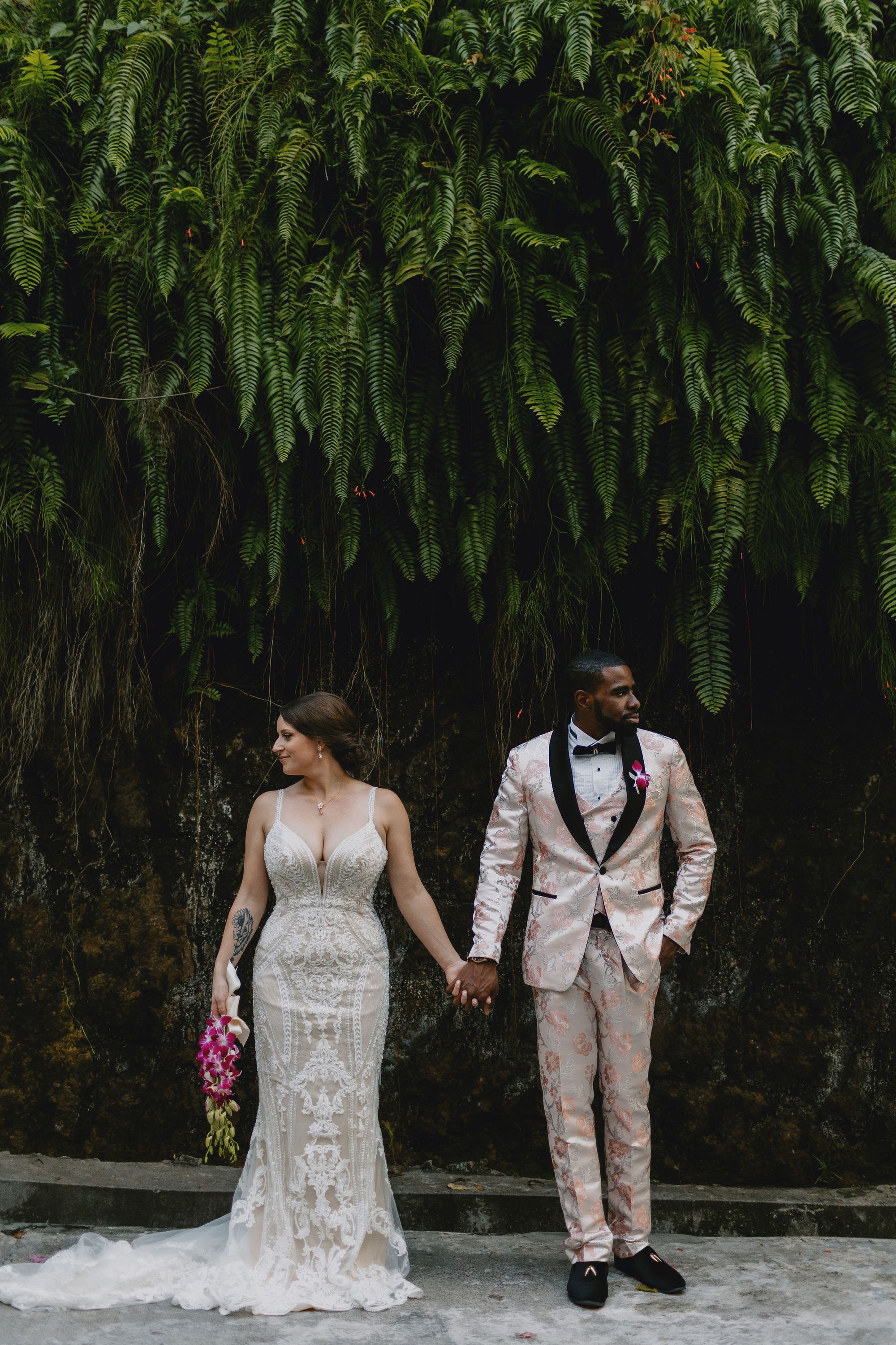 groom and bride holding hands looking in opossite directions