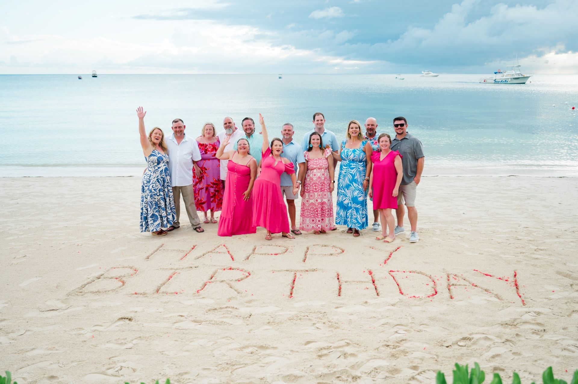 Guests gathered around "Happy Birthday" etched into the beach sand